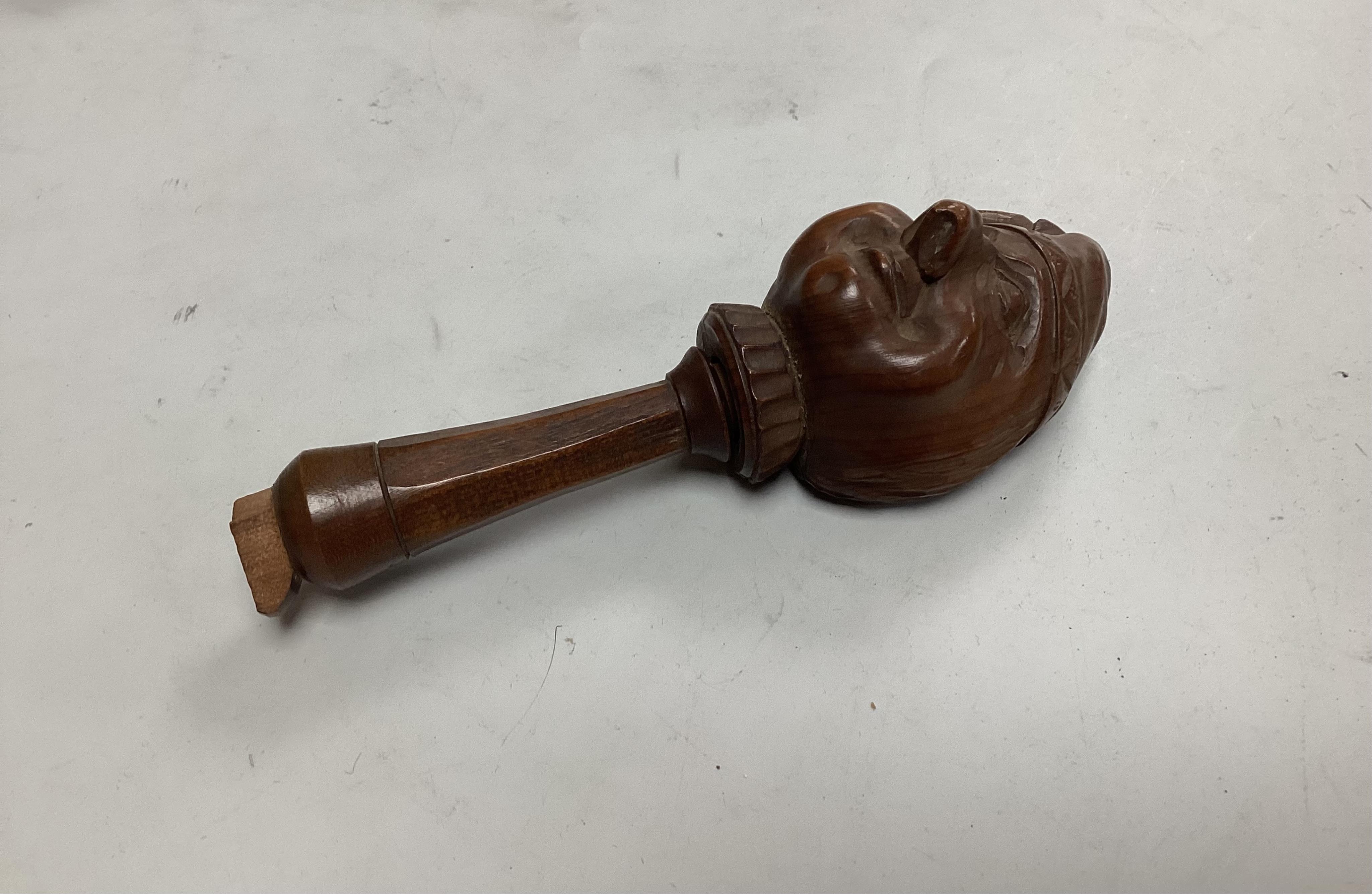 A pair of late 19th century Black Forest nutcrackers carvdd as a hare with glass eyes (loss) signed Champlex and a screw action novelty nutcracker carved with the head of a smiling man- 16.5cm high